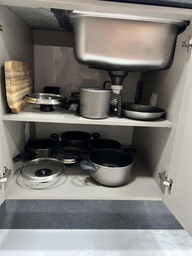 a kitchen with pots and pans on a shelf at BARRAVENTO RESIDENCE - RIVIERA SÃO LOURENçO in Bertioga