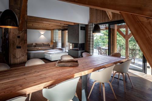 - un salon avec une grande table et des chaises en bois dans l'établissement Chalet de 8 chambres MEGEVE - 16 personnes, à Megève