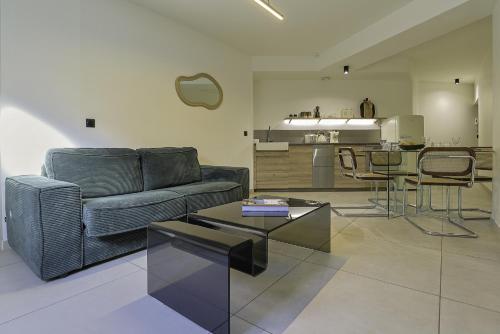 un salon avec un canapé et une table dans l'établissement Superbe Appartement 1 chambre avec clim, terrasse et parking, à Montpellier