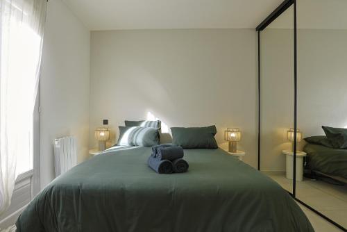 une chambre avec un grand lit avec deux serviettes dessus dans l'établissement Superbe Appartement 1 chambre avec clim, terrasse et parking, à Montpellier