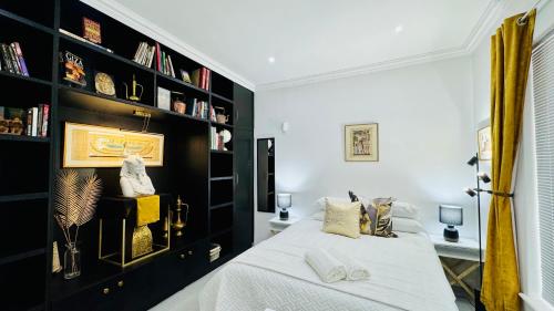 a bedroom with a bed and a book shelf at Cosy Family 2-Bedroom Cottage with Braai, Fireplace, Kitchen near Strand Beach in Strand