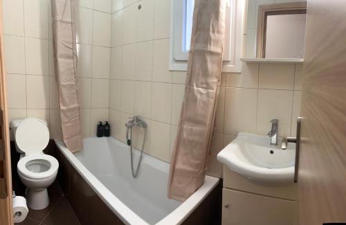 a bathroom with a tub and a toilet and a sink at Sweet Home Mitropoleos in Kastoria