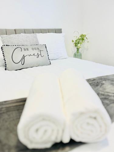 a bed with white sheets and towels on it at Clarence Road in Portsmouth
