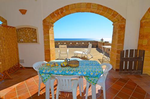 a room with a table with chairs and a view of the ocean at Casa Orizzonte in Patù