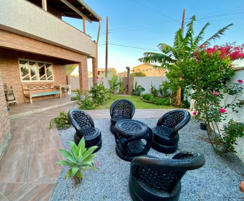 a group of black stools sitting in a yard at Apartamentos exclusivos e equipado com varanda ou terraço com Pôr do sol, cozinha privativa, Wi-Fi 600MBs, a 700m da praia de Itapirubá e 1km da BR-101 in Imbituba