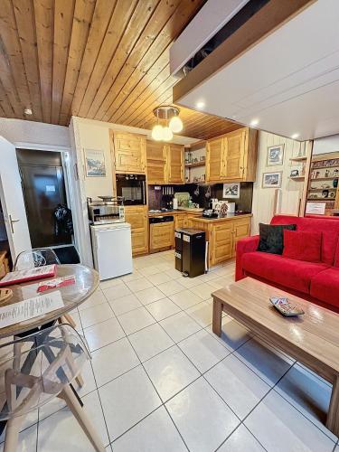 un salon avec un canapé rouge et une cuisine dans l'établissement Ladybird Inn, à Chamonix-Mont-Blanc