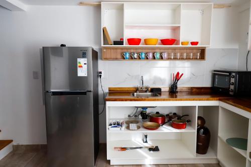 una cocina con nevera de acero inoxidable y armarios blancos en La Francisca, Alojamiento, en San Rafael