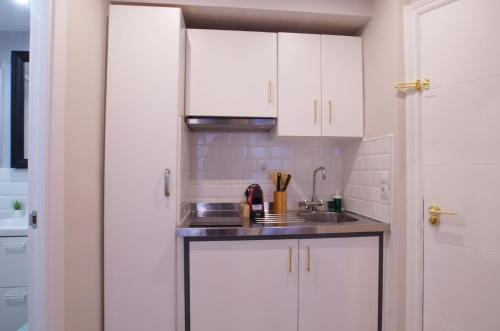 a kitchen with white cabinets and a sink at Budget Beach Studio 14 in Calonge