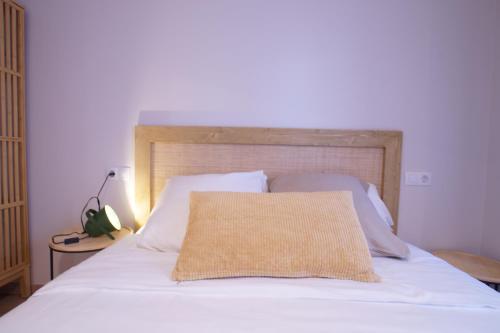 a bed with a wooden headboard and a pillow on it at Budget Beach Studio 14 in Calonge