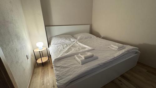 オロモウツにあるApartment Urban Oasisの小さなベッド(白いシーツ、タオル付)