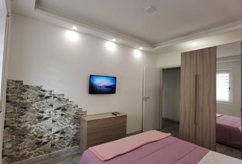 une chambre avec deux lits et une télévision au mur dans l'établissement porto, à Grado