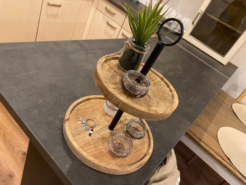 a table with two wooden tiers with glasses and a potted plant at Ferienwohnung Burgunderwiese in Bad Neuenahr-Ahrweiler