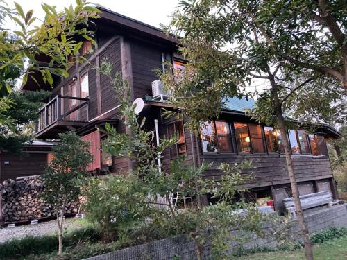 a wooden house with a balcony and trees at beau lac biwako in Takashima