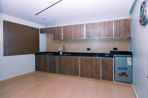 a kitchen with wooden cabinets and a refrigerator at Zawaya watan in Nizwa