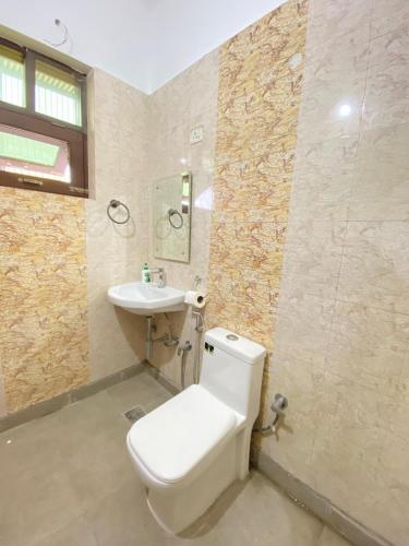 a bathroom with a toilet and a sink at House Of Vedas in Greater Noida