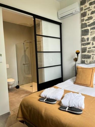 - une chambre avec un lit, des serviettes et une douche dans l'établissement Studio apartment in the South Ardèche, à Saint-André-de-Cruzières