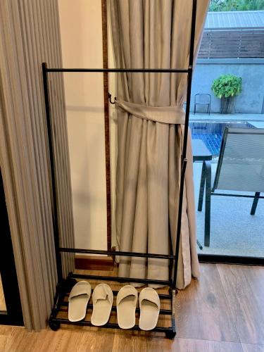 a pair of white shoes on a stand next to a window at Baan Fran Sim Da in Bang Tao Beach