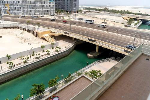 a bridge over a river next to a highway at Chic 1BR for 3 Guests - Modern Al Reem Island Retreat Near Al Reem Mall in Abu Dhabi