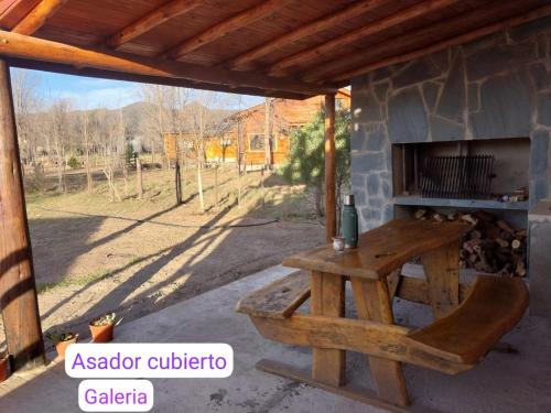 a picnic table in front of a stone fireplace at Cabaña Lago y Luna in Villa Ciudad Parque