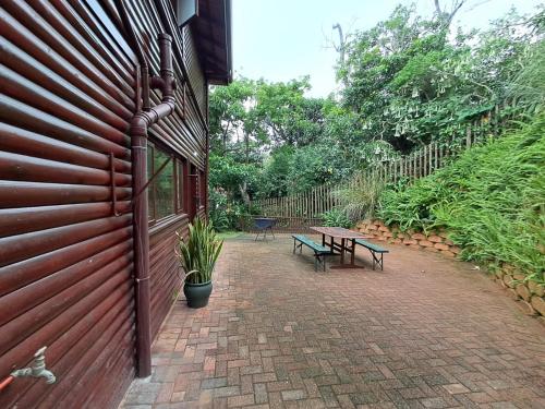a patio with two benches next to a building at Townhouse at Eagles Nest, Southport, KZN south coast in Port Shepstone