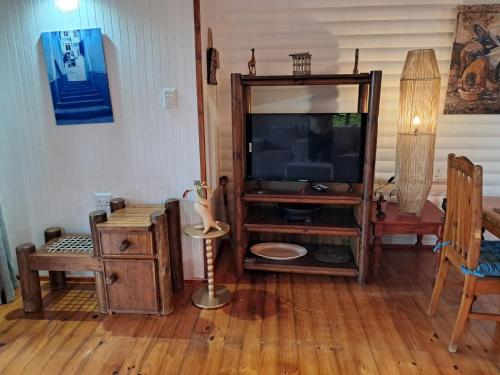 a living room with a tv and a wooden floor at Townhouse at Eagles Nest, Southport, KZN south coast in Port Shepstone