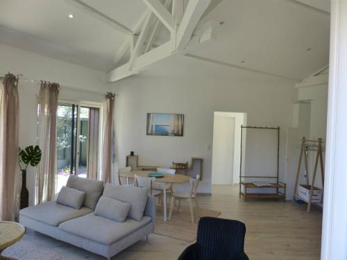 un salon avec un canapé et une table dans l'établissement HOSSEGOR PLAGE- Villa PAUL -Petite villa rénovée pour 4 personnes- Wifi gratuit, à Hossegor