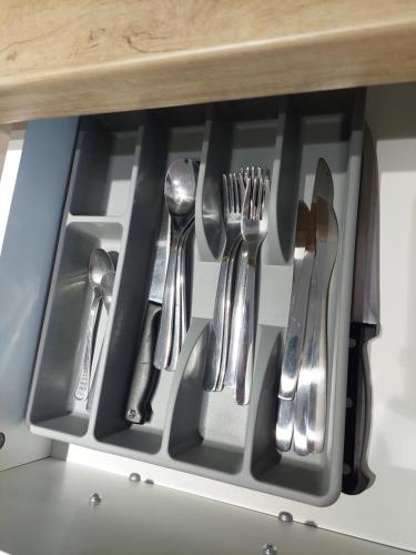 a drawer filled with utensils in a kitchen at Apartman Anna Srebrno jezero in Veliko Gradište