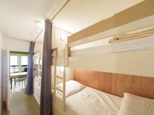une chambre avec deux lits superposés et une table dans l'établissement Spacieux appart 6 pers avec loggia à Gourette - FR-1-400-127, à Eaux-Bonnes