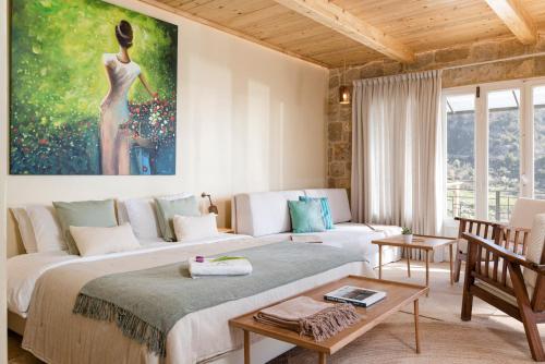 a living room with a bed and a painting of a woman at Casadar Guesthouse in Ash Shi‘b
