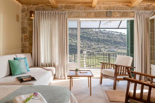 a living room with a couch and a large window at Casadar Guesthouse in Ash Shi‘b