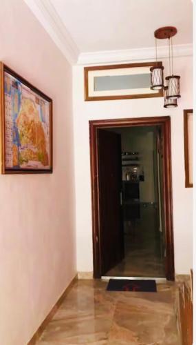 a hallway with a door and a painting and a picture at Belle maison familiale spacieuse à Dakar Sénégal HOME TERANGA in Dakar