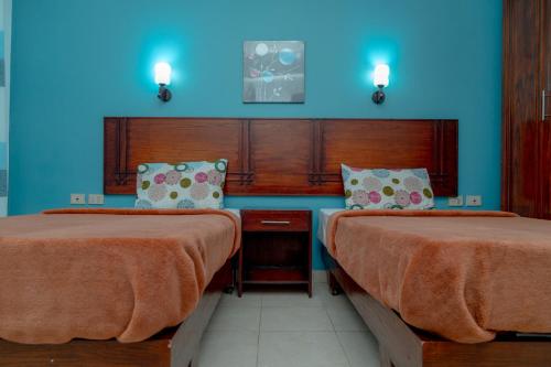 a room with two beds and a blue wall at Sea Life Apartments-hotel in Hurghada