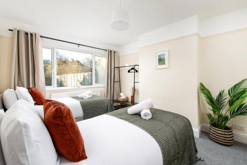 a bedroom with two beds and a window at Long Stays-4bed house-Parking-By FabAccommodation in Bristol