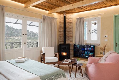 a bedroom with a bed and a fireplace and a television at Casadar Guesthouse in Ash Shi‘b