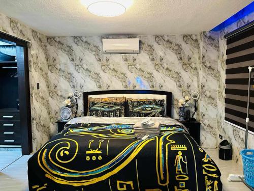 a bedroom with a bed with a black and yellow blanket at Angeles City Apartment in Santol