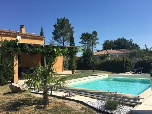 une piscine dans une cour à côté d'une maison dans l'établissement Villa Sérénitude, à Salavas