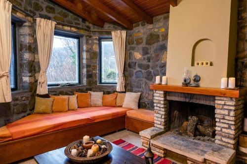 a living room with a couch and a fireplace at Τείχιο Mariandas House - Tihio - Πέτρινη κατοικία in Tíkhion