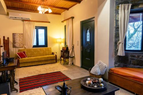 a living room with a yellow couch and a green door at Τείχιο Mariandas House - Tihio - Πέτρινη κατοικία in Tíkhion