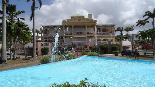 a fountain in front of a building with a building at Holidays Guadeloupe -Paradise -Anse des Rochers in Belle-Allée