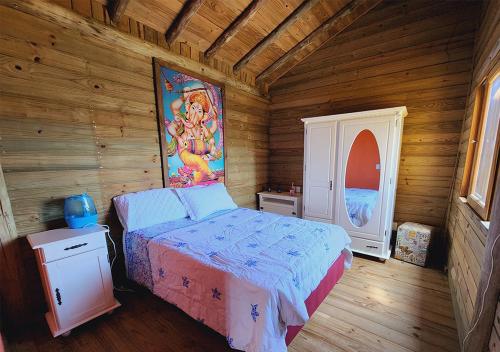a bedroom with a bed and a painting on the wall at Casa do Mirante - Ribanceira in Imbituba