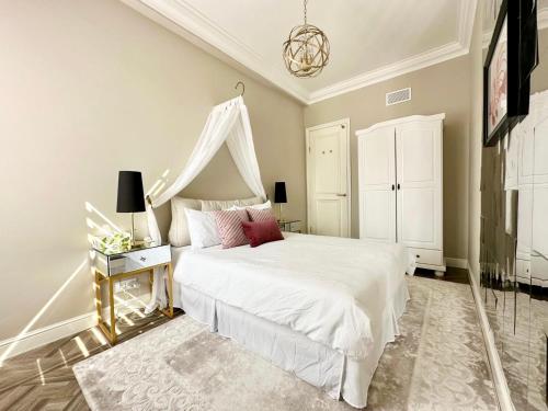 une chambre avec un lit blanc à baldaquin dans l'établissement Magnifique 1 Chambres Plein Centre Juan les Pins 50m des Plages, à Antibes