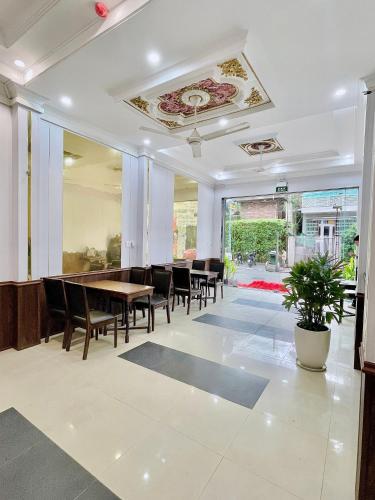 a dining room with tables and chairs and a ceiling at Amy Hotel Hue in Hue