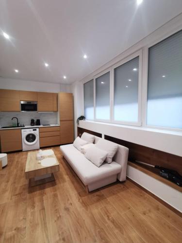 un salon avec un canapé blanc et une table dans l'établissement Le Strasbourgeois Moderne & Neuf Voyage en Alsace, à Strasbourg