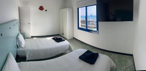 a hotel room with two beds and a window at Casa maría in Costa Teguise