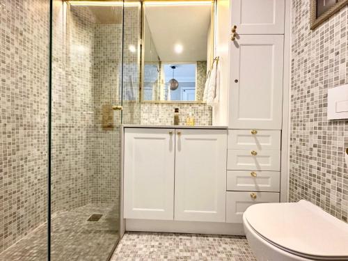 une salle de bain blanche avec douche et toilettes dans l'établissement Magnifique 1 Chambres Plein Centre Juan les Pins 50m des Plages, à Antibes