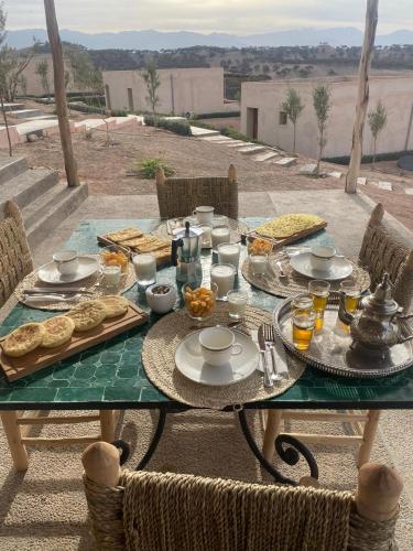 a table with plates of food on a patio at TOUGYA Ecolodge Near Agafay Desert in Marrakech