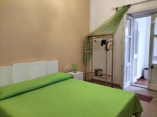 a bedroom with a green bed with a green blanket at Casa al tramonto...sunset lovers retreat in Lipari