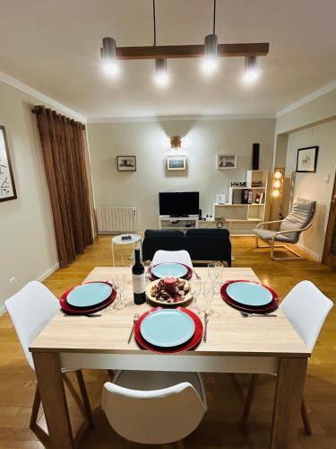 a wooden table with white chairs and a dining room at Casa do Souto - City in Bragança