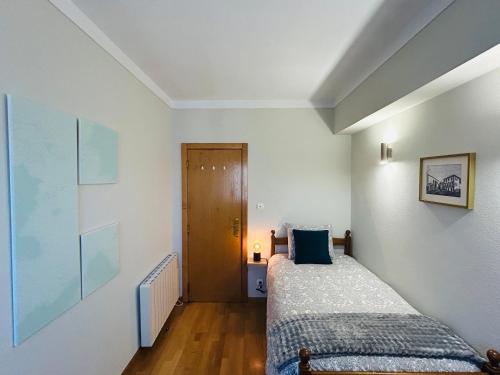 a bedroom with two twin beds and a door at Casa do Souto - City in Bragança