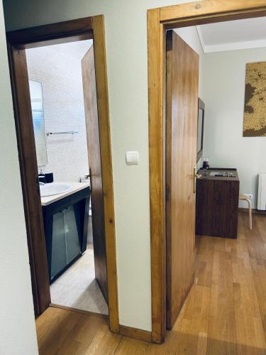 an open door to a bathroom with a sink at Casa do Souto - City in Bragança